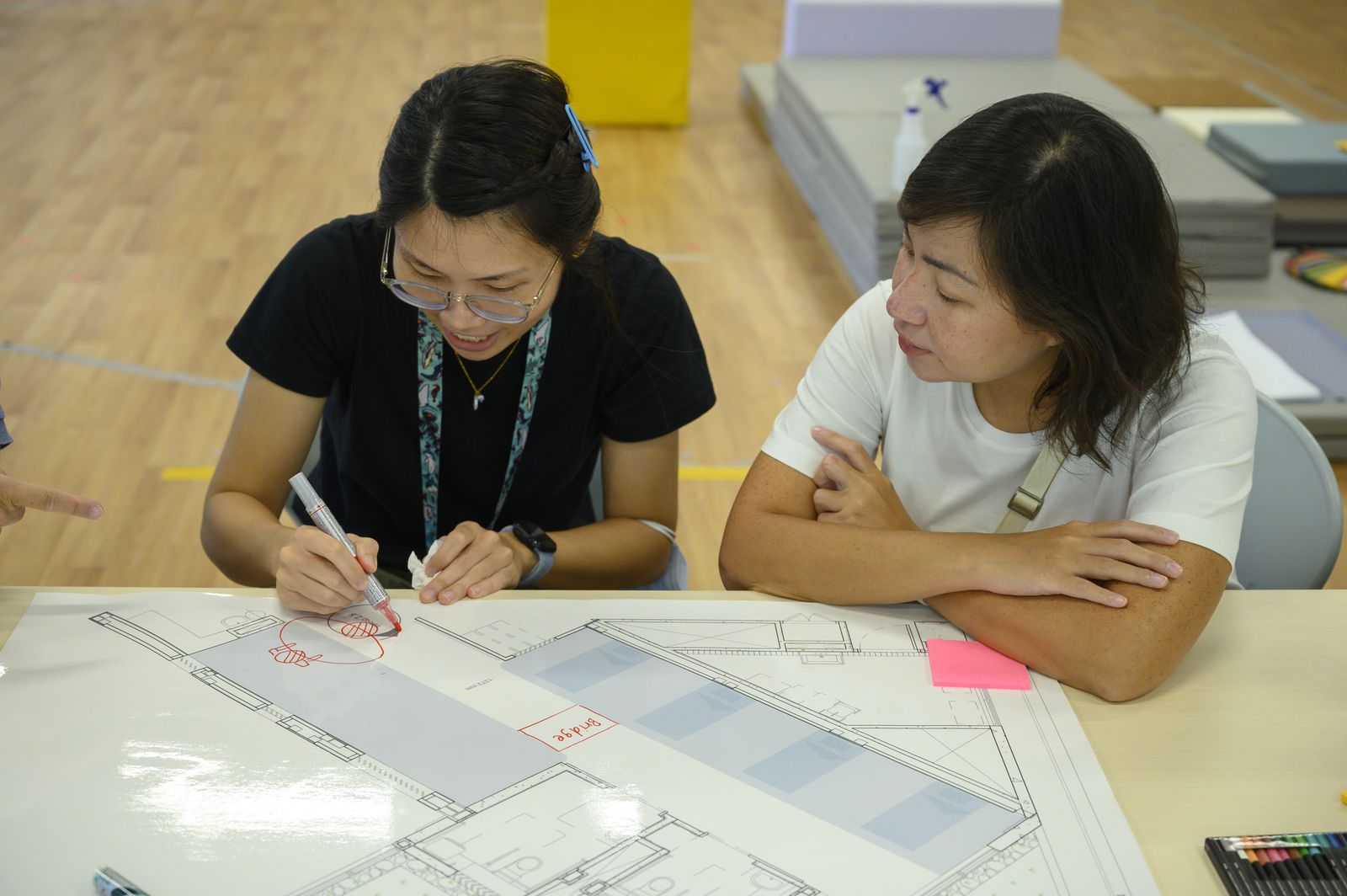 Two staff members marking up the ward plan together