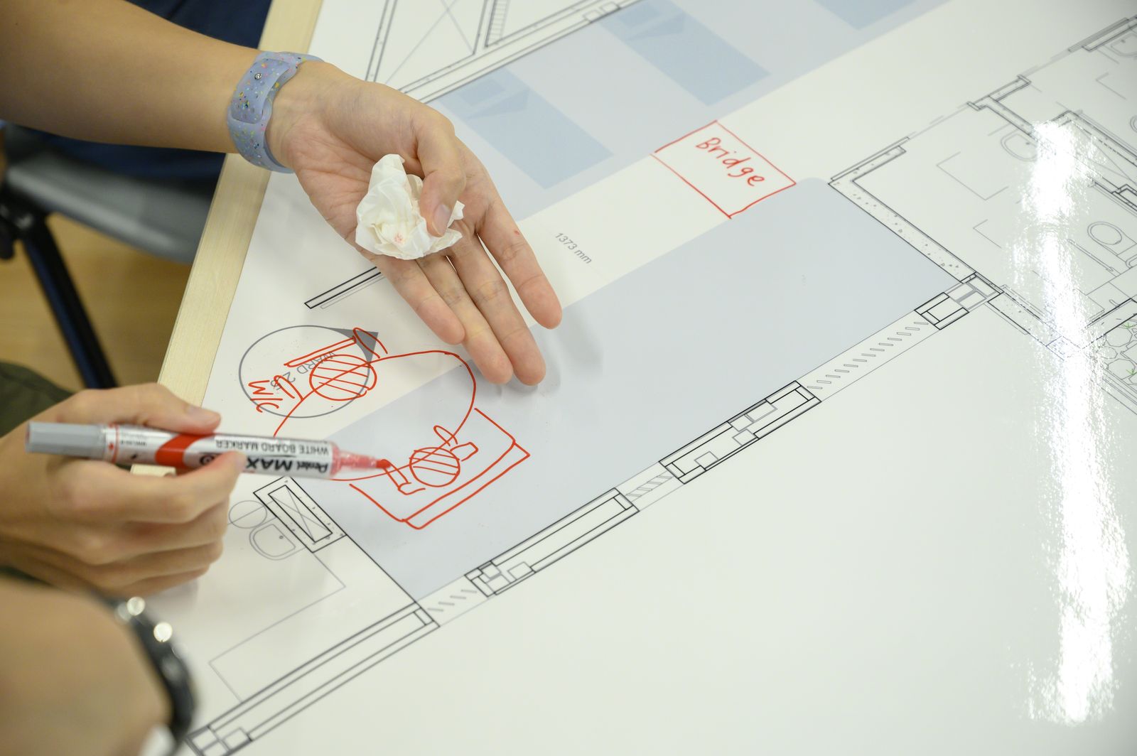 Sketching furniture positions on the plan with a red marker