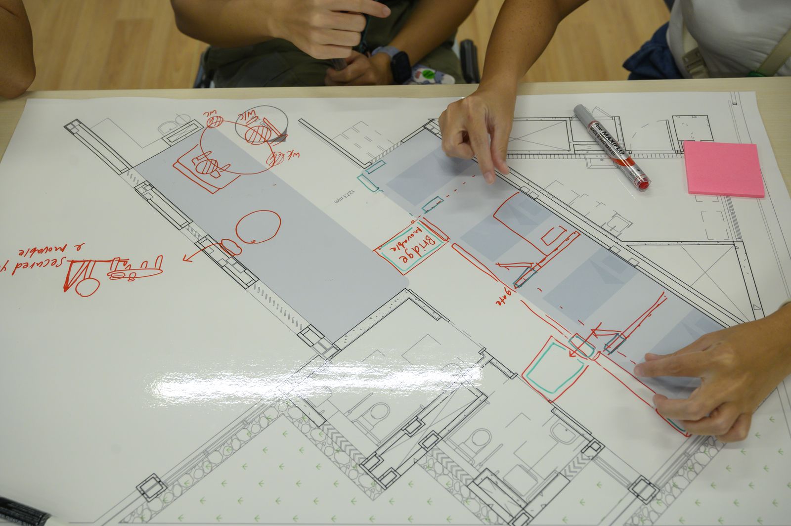 Hands drawing over the printed ward layout