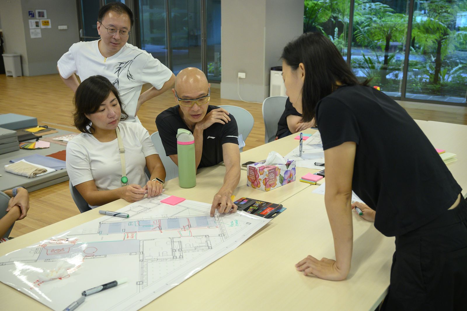 The team leaning over the plan during a co-creation session