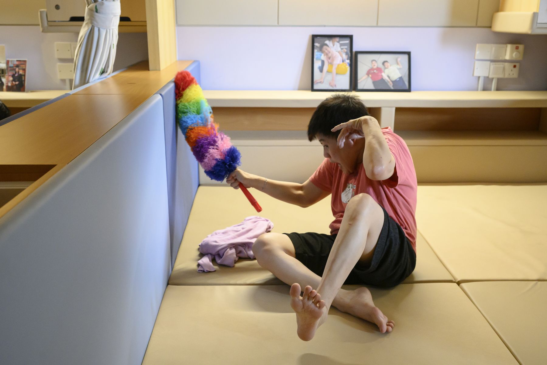 A resident tidying her own space with a duster