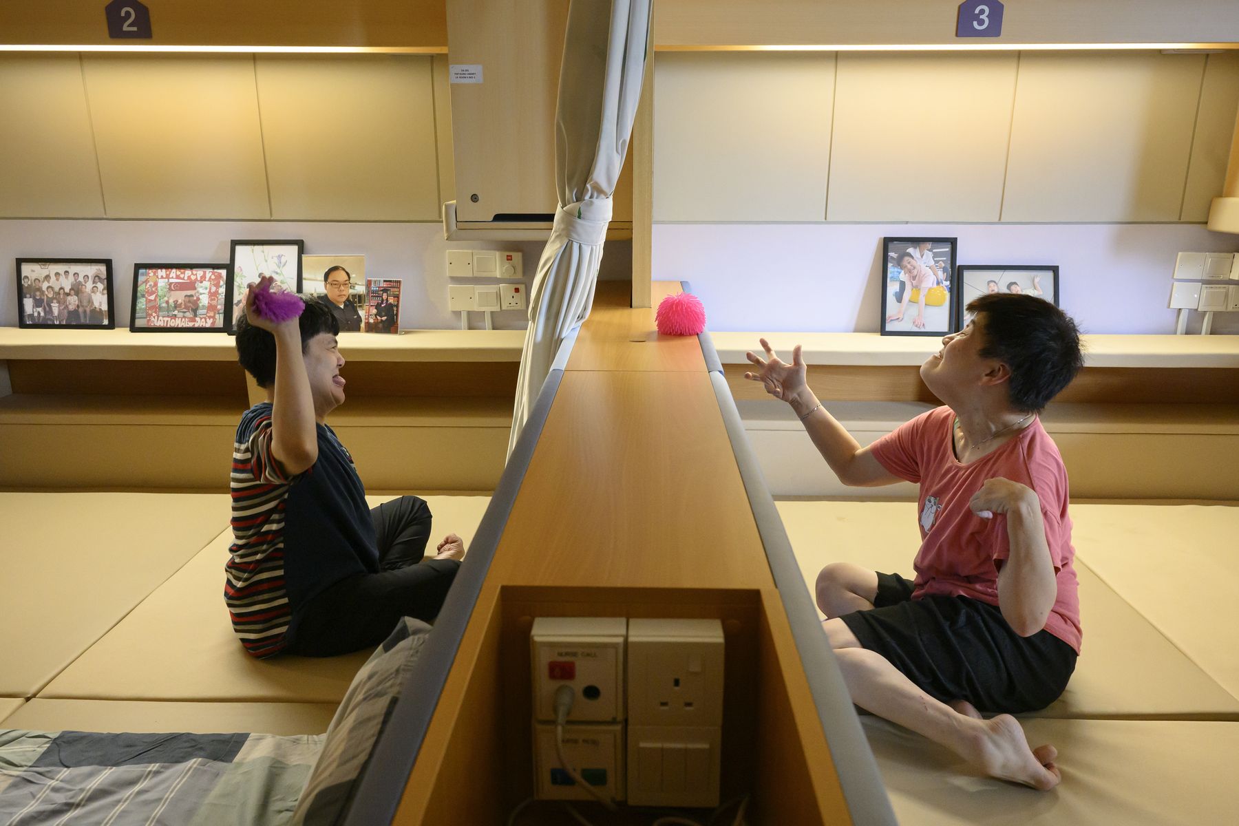 Two residents on either side of a low divider, playing with a ball