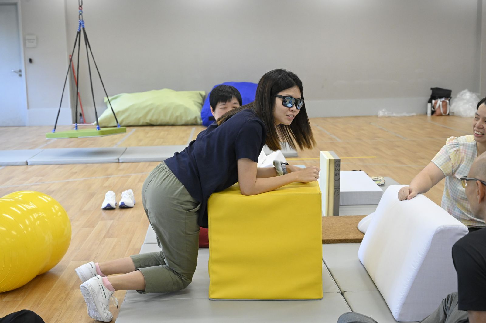 Kneeling against a yellow foam cube