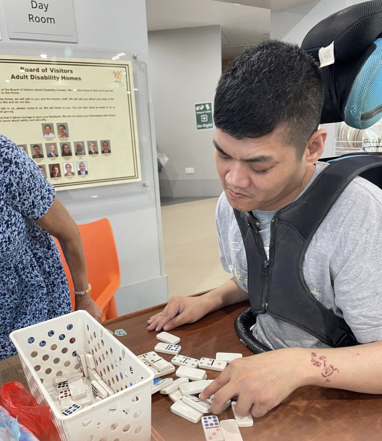 A resident playing dominoes in the day room