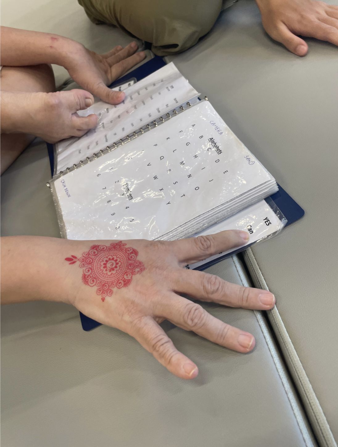 Close-up of a resident’s hand with henna, resting on a picture book