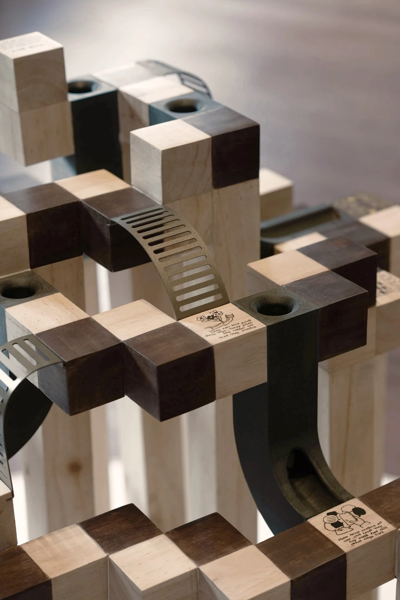 A close view of the bent aluminium ladder and contrasting solid wood blocks.