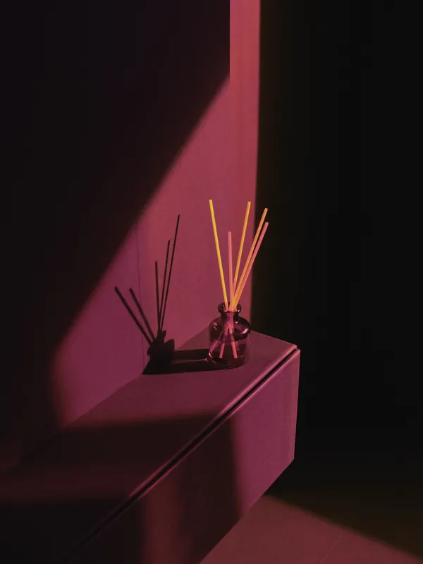 A lavender reed diffuser on a black cabinet