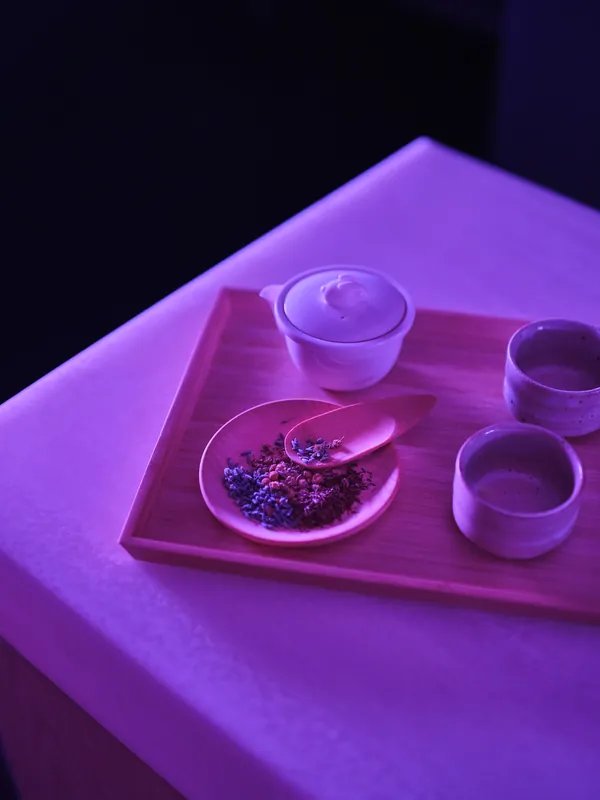 A tray with a teapot, two cups and dried chamomile