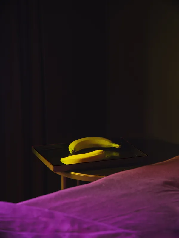Two bananas on a bedside table