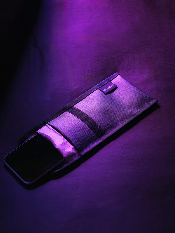 A phone sealed in a black signal-blocking pouch
